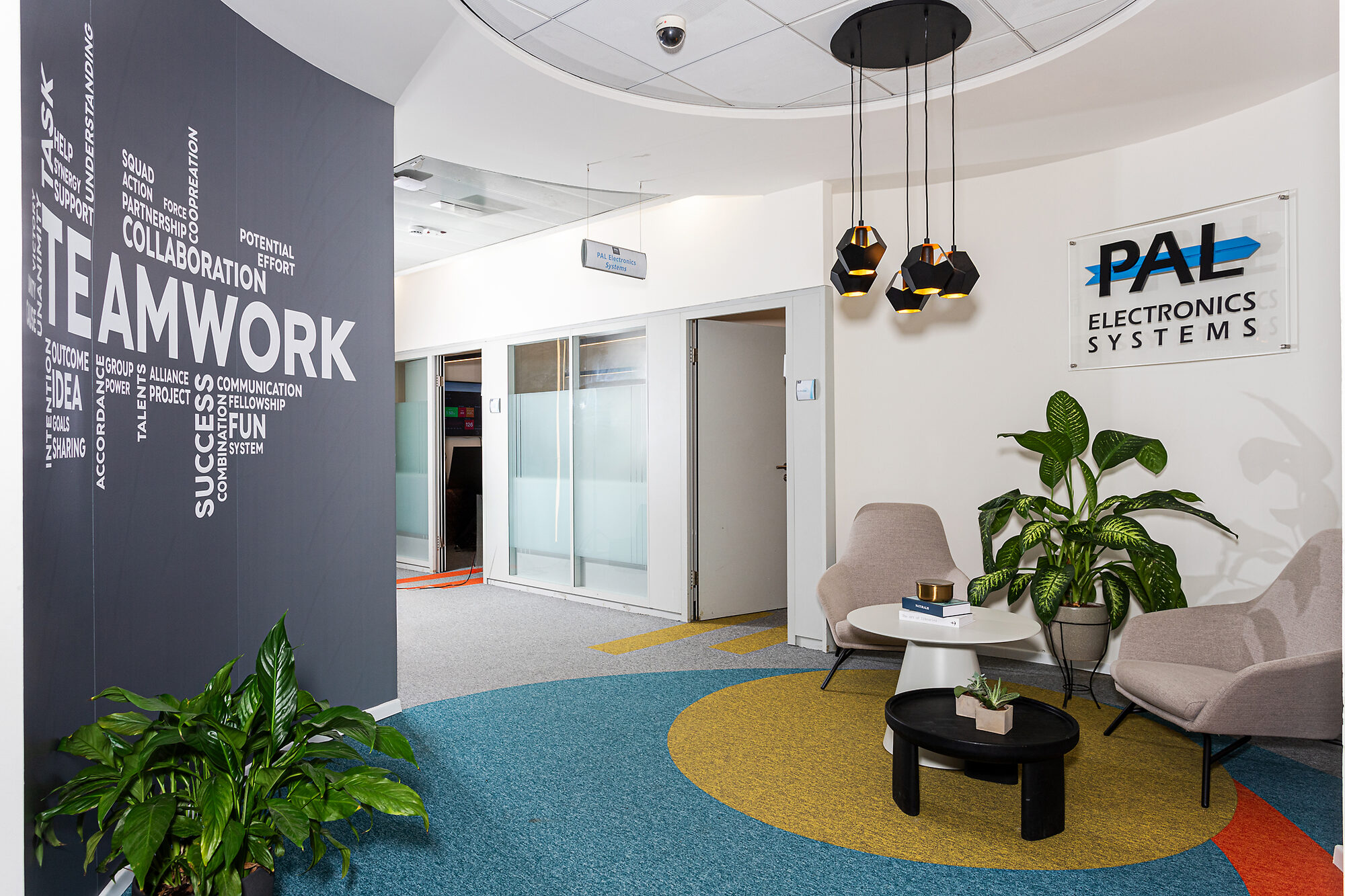Reception area at the PAL office, with a teamwork wall and the PAL sign